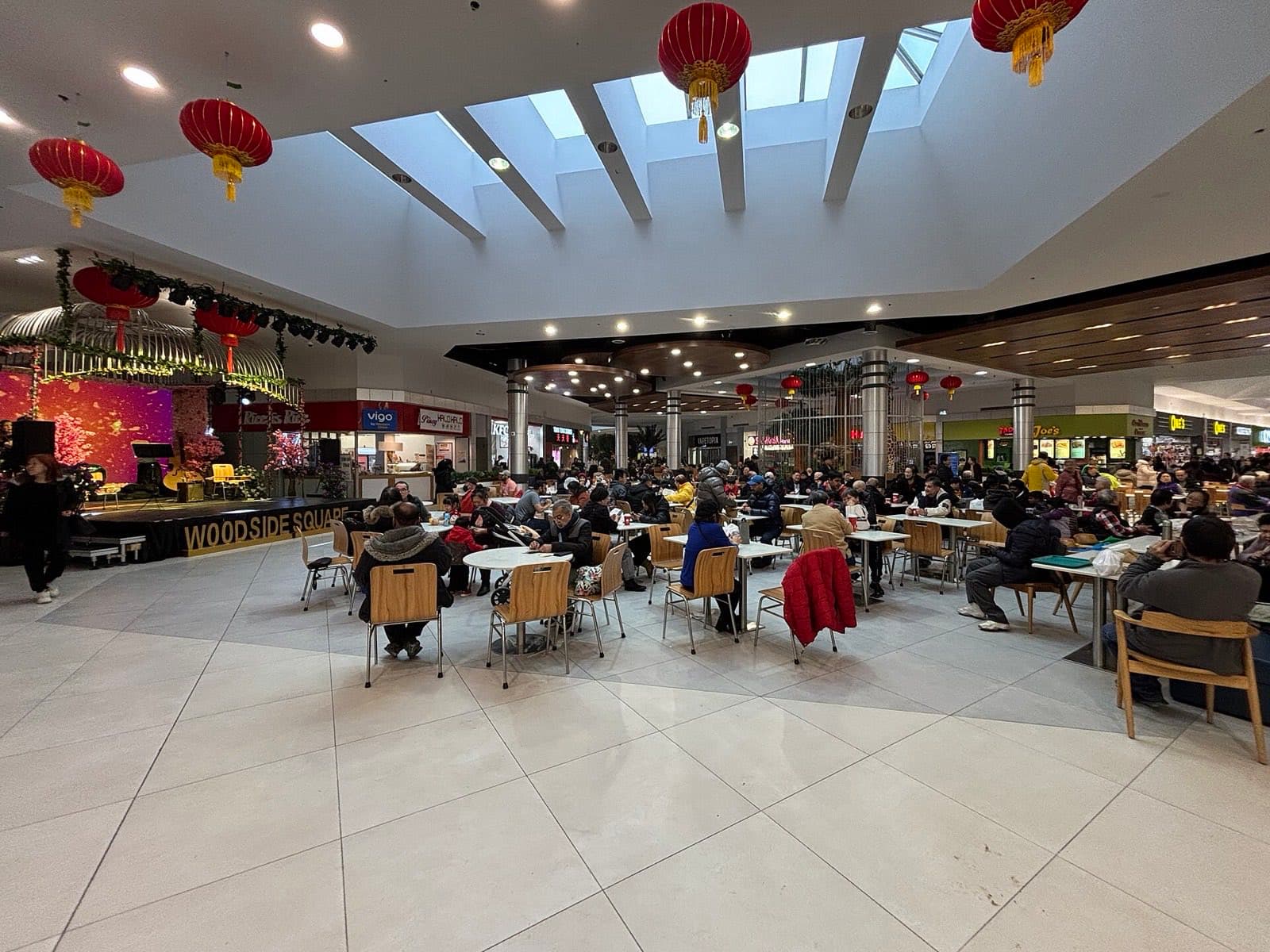 The interior of a shopping centre with shopfronts and seating