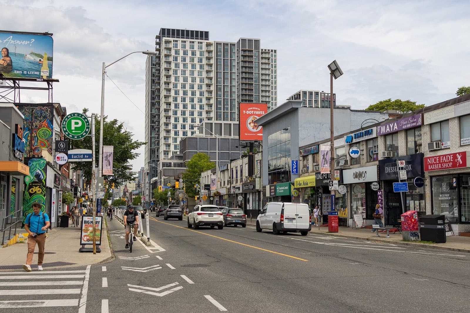 Shops and low buildings along a wide street with streetcar wires overhead