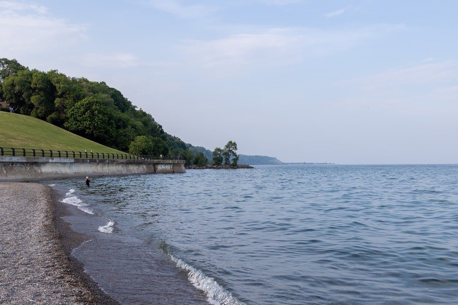 A grass bank running down to the shore of Lake Ontario