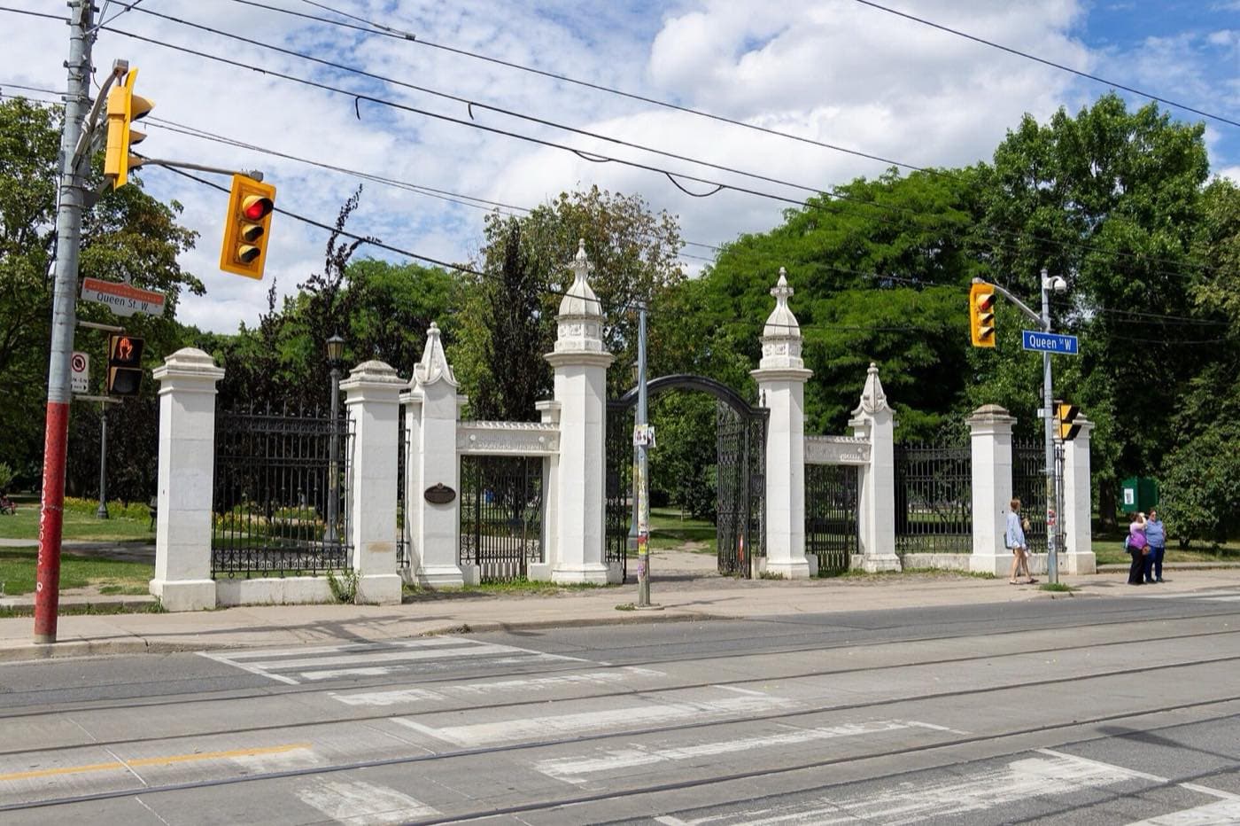Stone gateposts at a park entrance on a busy street