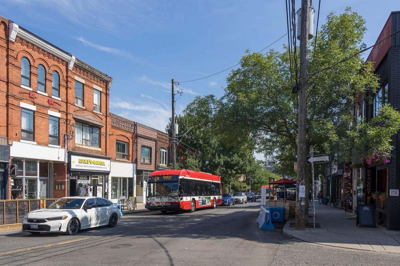 Brick storefronts with flats above them, a streetcar in the distance